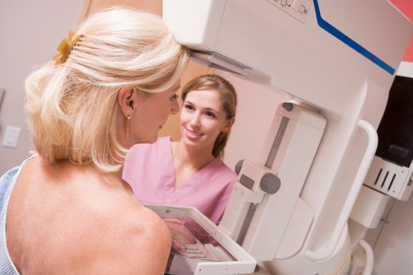 A woman is shown getting a mammogram.