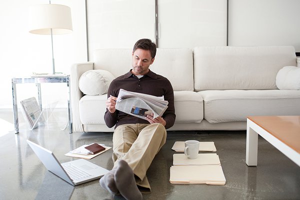 Man on his couch reading a newspaper