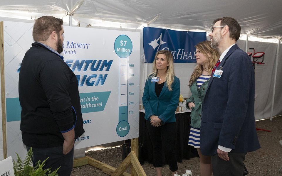 CoxHealth employees review the Momentum Campaign poster