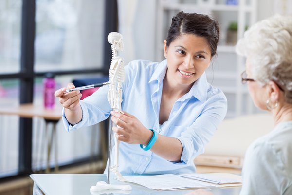 A provider educates a patient about bone health.