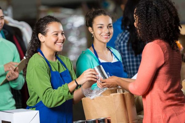 A picture shows women with bags of food.