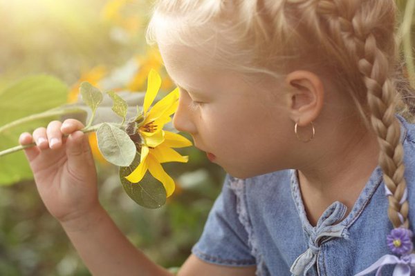 Young girl smelling a flower