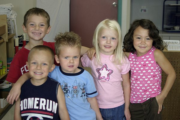 Group of five kids posing for a picture