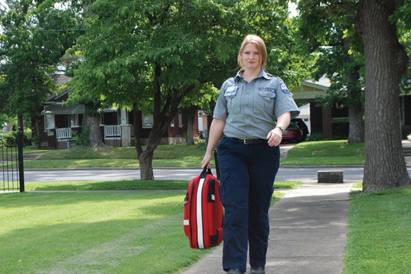 Female paramedic walking on the sidewalk