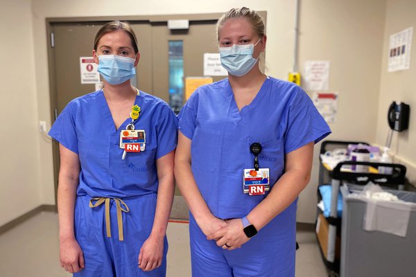 Olivia Montgomery and Amelia Caudle stand outside the COVID-19 ICU at Cox South.