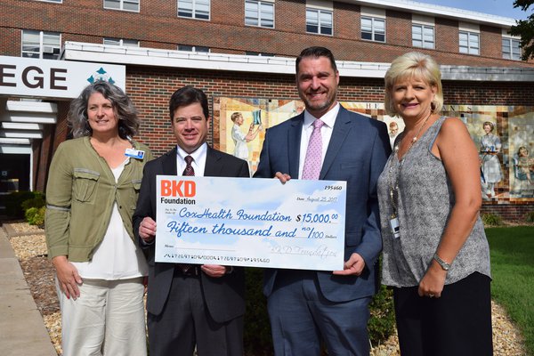 Dr. Amy DeMelo, president of Cox College; Eddie Marmouget, national industry partner for BKD's health care practice; Andy Williams, partner in BKD's health care practice; and Lisa Alexander, president of the CoxHealth Foundation hold a $15,000 check.