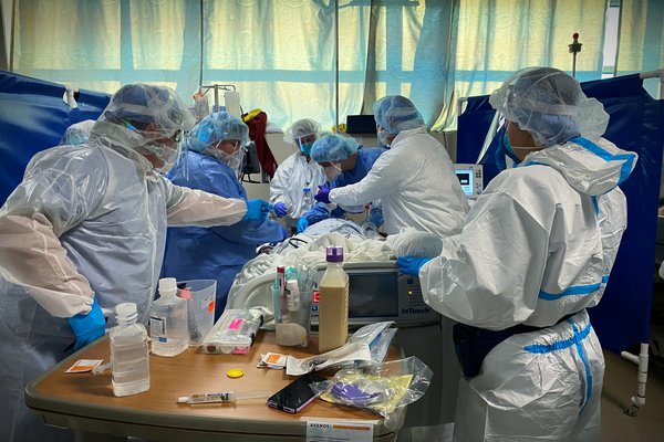 An image shows a team serving a patient in the Cox South COVID unit.