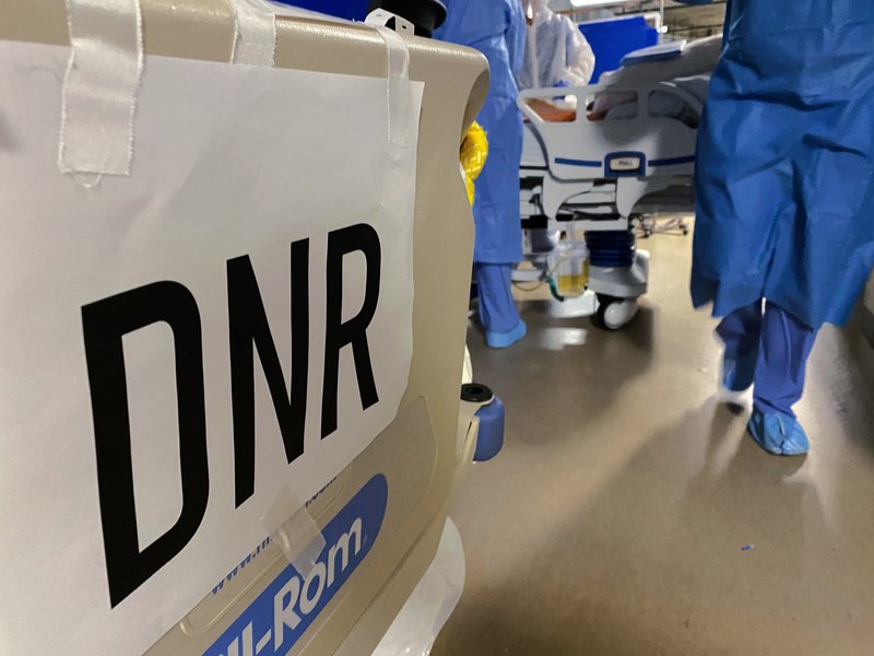 A DNR sign is taped to the end of a bed.