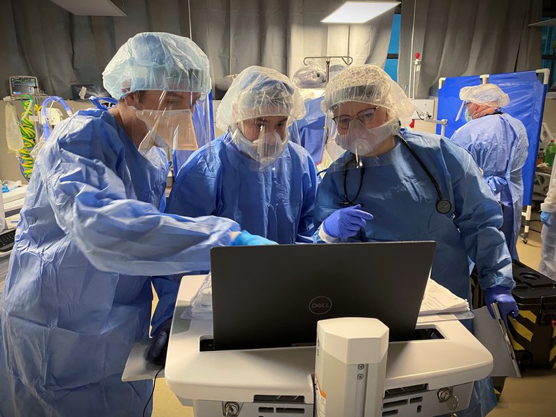 An image shows health care workers at a computer.