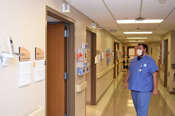 Male nurse walks into a patient room to answer a call light.