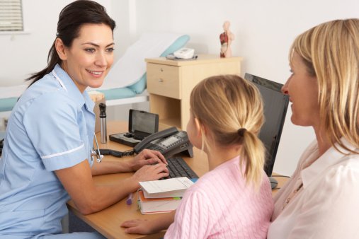 A child and parent visit with a medical provider at an appointment.