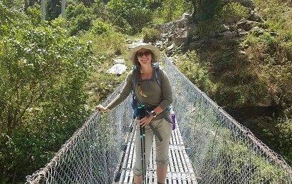 Dr. Born hiking outdoors crossing bridge
