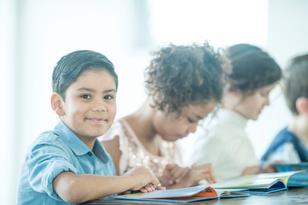 Children reading a book in class