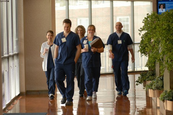 A group of employees walk down the hall.