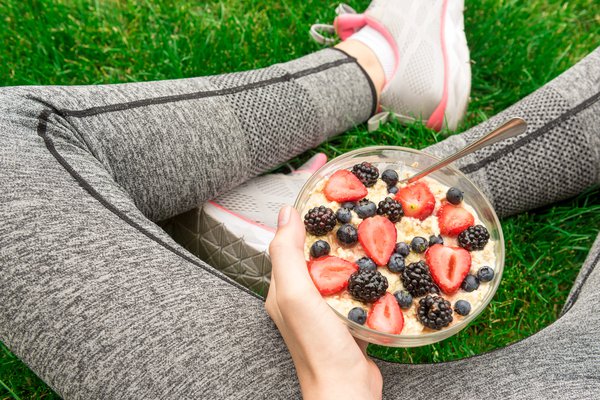 A person sits with a bowl of food.