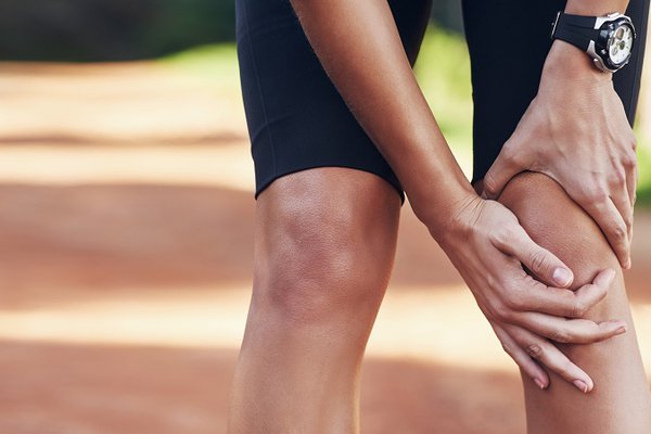 A man with an orthopedic injury holds his knee.