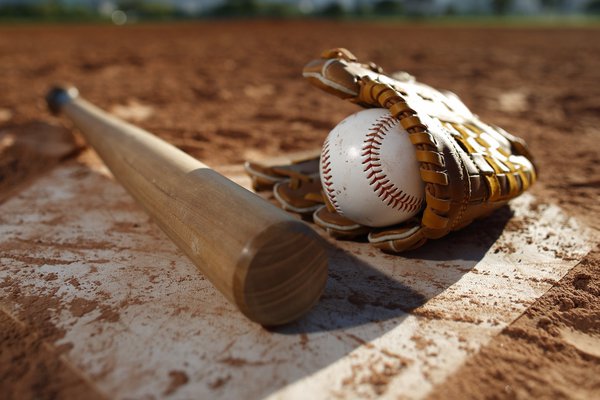 A photo shows a baseball field with glove, ball and bat.