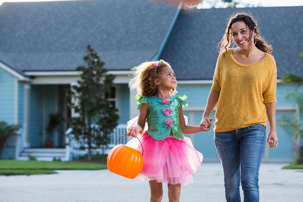 Woman taking her daughter trick or treating