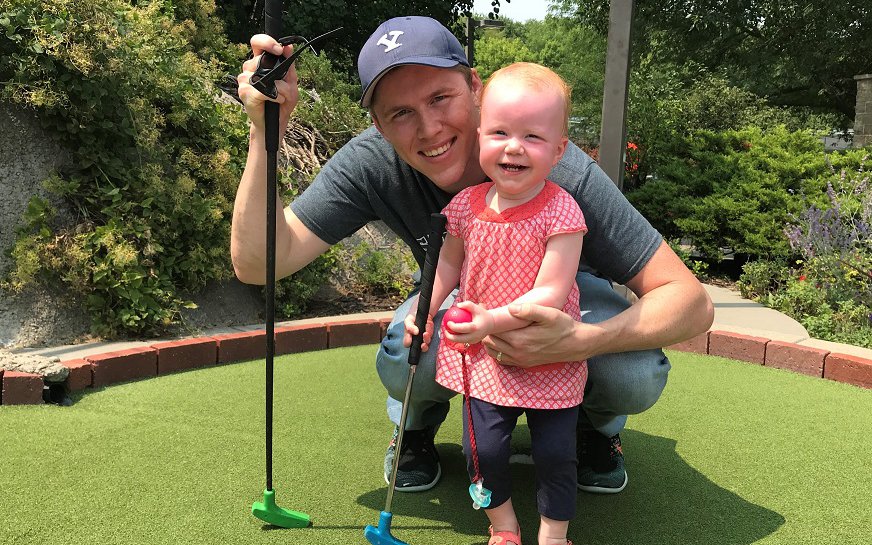 Dr. Hansen with a young child playing putt putt golf.