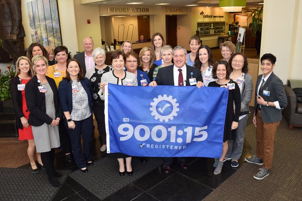 CoxHealth leaders and employees gather to hoist the ISO 9001 flag that now flies at Cox South.