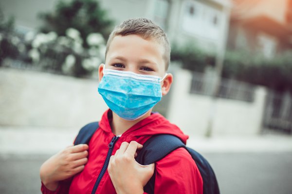 A photo shows a child wearing a mask.