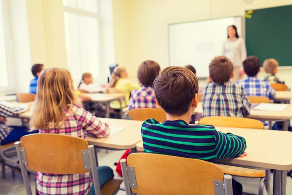 Classroom full of children listening to teacher.