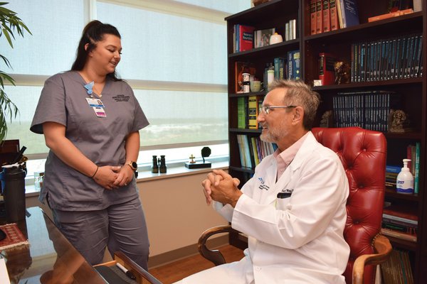 A medical assistant apprentice speaks with a physician.