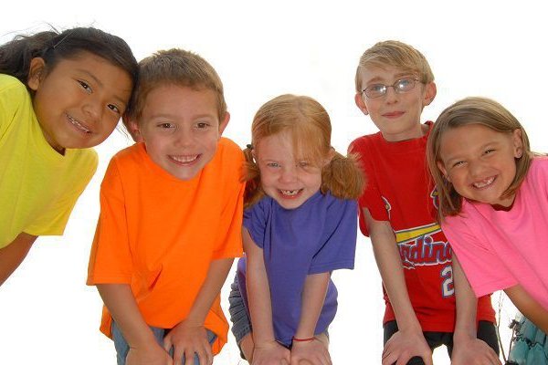 A group of children smile at the camera.