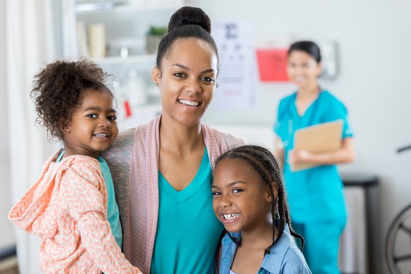 Children and an adult are pictured in a medical facility.