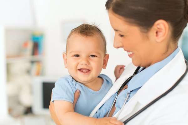A provider holds a smiling baby.