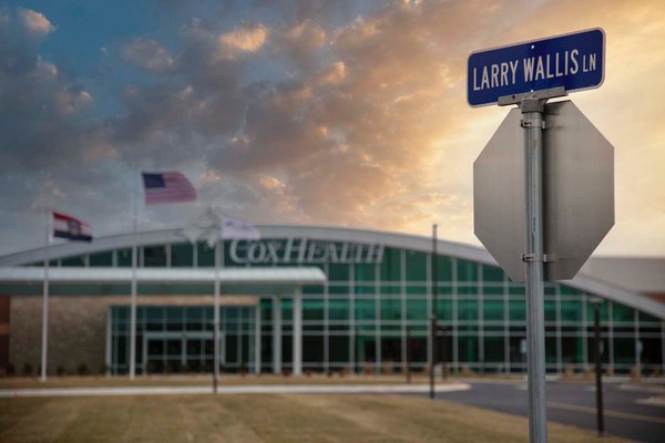 A photo shows the sign honoring Larry Wallis at Cox Monett.