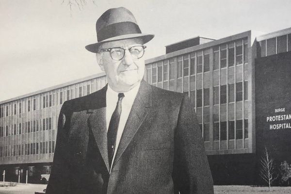 Lester E. Cox stands in front of Burge-Protestant Hospital.