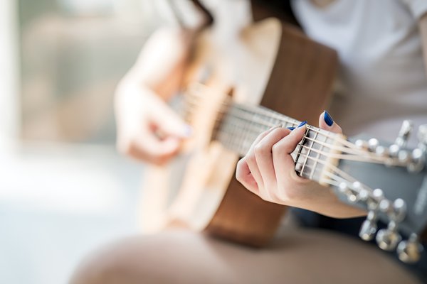 A woman plays the guitar.