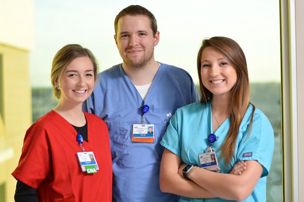 A group of employees is pictured near a window.