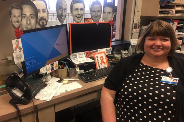 Joyce sitting in front of her desk.