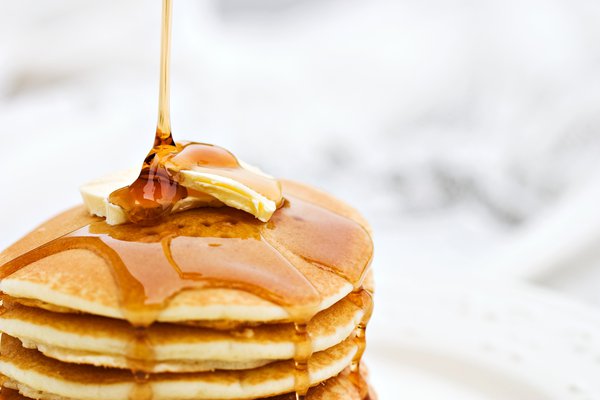 Stack of pancakes with butter and syrup.